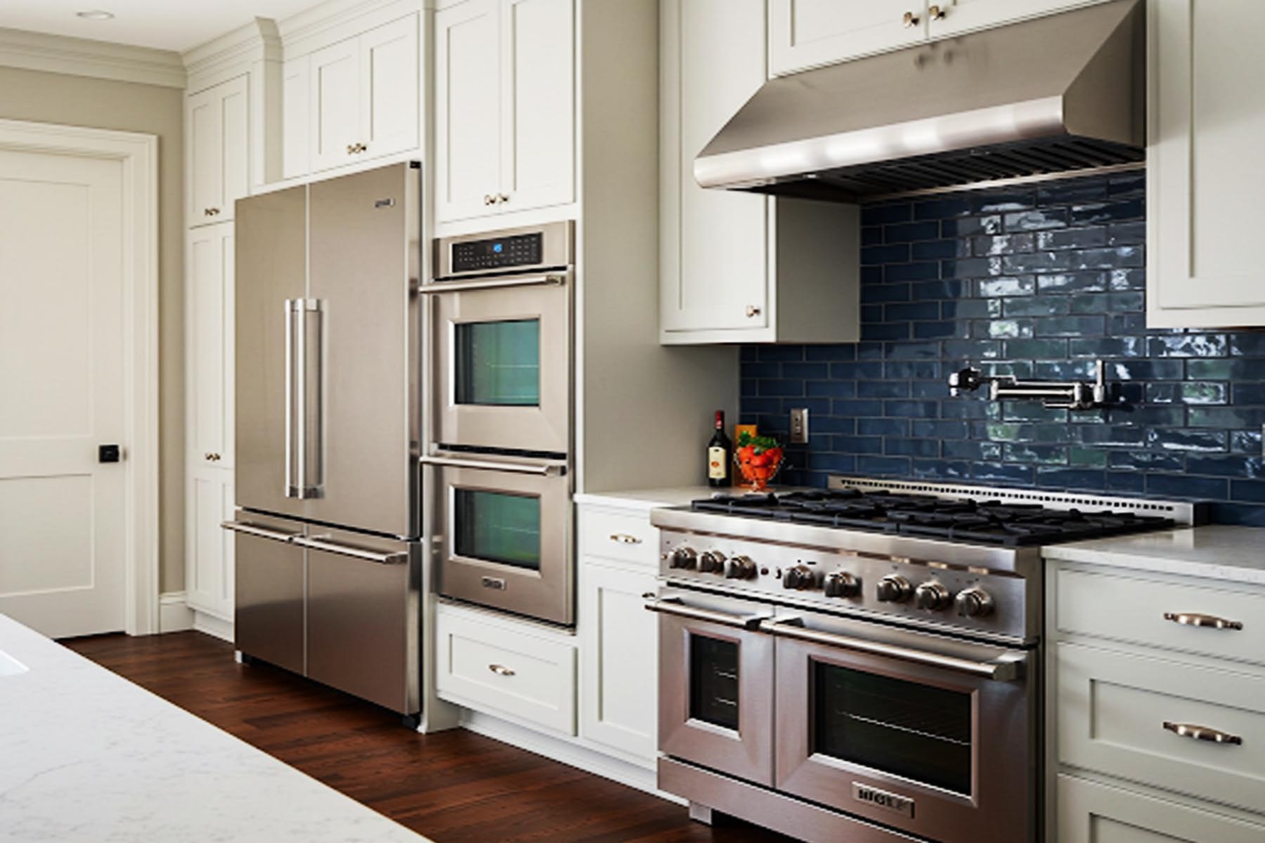 A modern kitchen featuring a Sub-Zero refrigerator, Wolf range, Miele dishwasher, Viking oven, and Thermador oven, all stainless steel, arranged in a functional layout in Dripping Springs TX